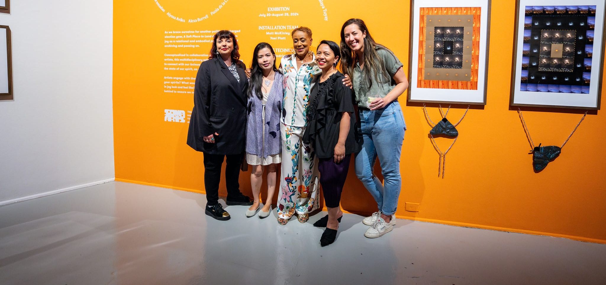 The Board Chair opportunity header photo features two board members side on either side of SOMArts' executive director in front of a yellow vinyl wall during the opening reception of 'A Soft Place to Land'